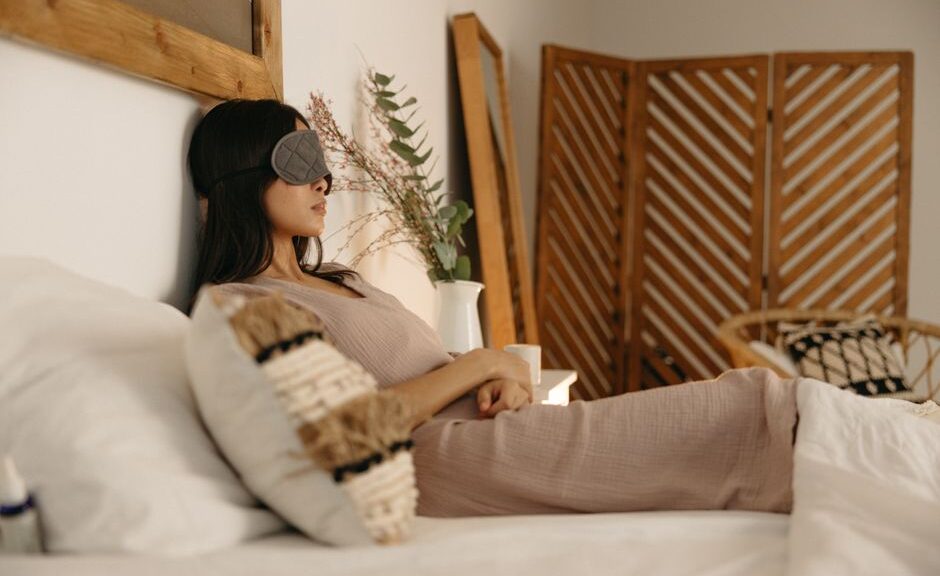 Een serene slaapkamer met verschillende slaaphulpmiddelen zoals een ergonomisch hoofdkussen en een verzwaringsdeken.