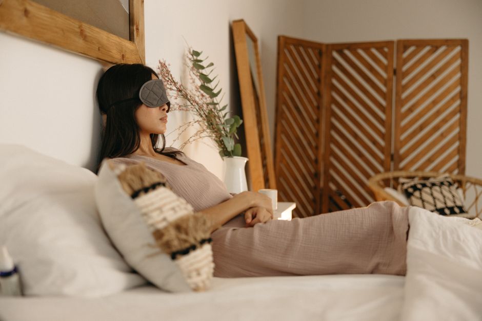 Een serene slaapkamer met verschillende slaaphulpmiddelen zoals een ergonomisch hoofdkussen en een verzwaringsdeken.